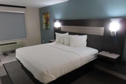 1 cama blanca grande en una habitación de hotel en Best Western Prime Inn & Suites, en Poteau