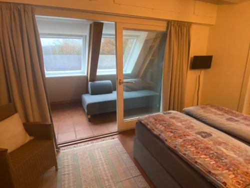 a hotel room with a bed and a chair and a window at Ferienwohnung An der Farchauer Mühle in Schmilau