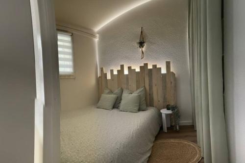 une chambre avec un lit avec une tête de lit en bois dans l'établissement Maison de plage - 6 pers - clim - parking, à Frontignan