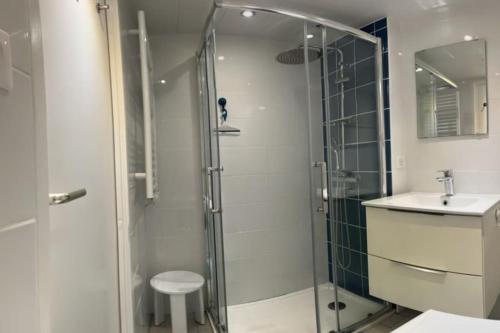 une salle de bain avec une douche en verre et un lavabo dans l'établissement Maison de plage - 6 pers - clim - parking, à Frontignan