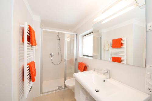 a white bathroom with a sink and a shower at Apartment Edelweiss in Brunico