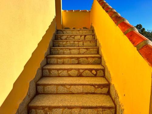 a set of stairs with a yellow wall at Hotel I Menhirs in Annunziata