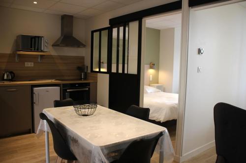 um quarto com uma mesa, uma cozinha e uma cama em Villa Marronniers - Superbe appartement neuf, 4 personnes em Bourbon-Lancy