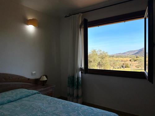 a bedroom with a bed and a window with a view at Hotel I Menhirs in Annunziata
