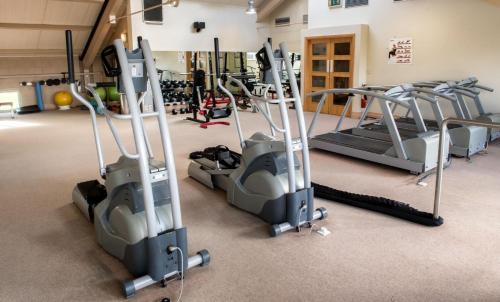 a gym with several treadmills and elliptical machines at Castlerosse Park Resort in Killarney
