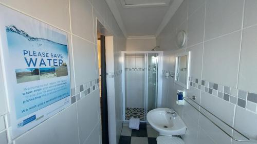 ein Bad mit einer Dusche, einem Waschbecken und einem WC in der Unterkunft SuNel's Guest Rooms in Malmesbury