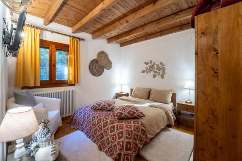 sypialnia z łóżkiem w pokoju z drewnianym sufitem w obiekcie Dandy on the hill Chalet Artemis - Fir Forest - Jeep & Nature Lovers w mieście Eptalofos