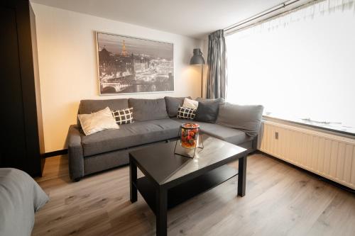 a living room with a couch and a coffee table at Le Studio by La Reine City Center in Spa