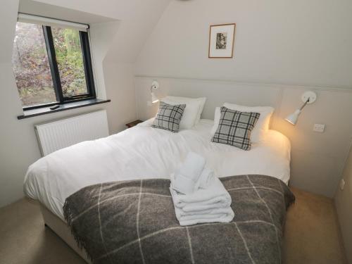 ein Schlafzimmer mit einem Bett mit einem Stapel Handtücher drauf in der Unterkunft The Cottage in Chipping Campden