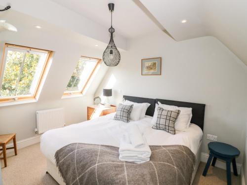a bedroom with a large white bed with pillows at The Old Stables in Chipping Campden