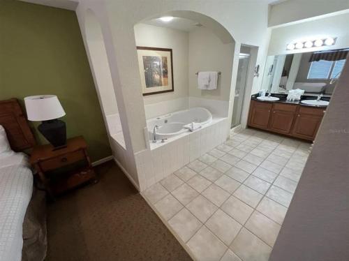 a large bathroom with a tub and a bedroom at Best Disney Resort Condo Orlando in Orlando