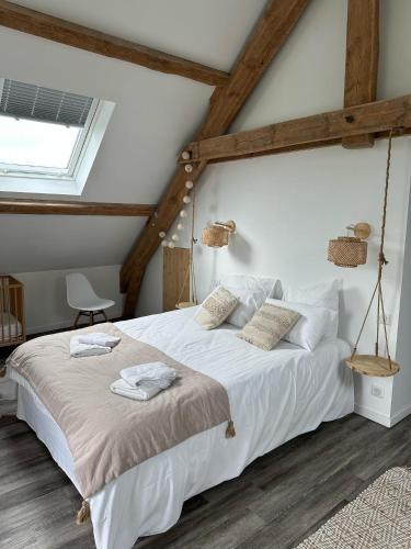 une chambre avec un lit avec des draps blancs et une fenêtre dans l'établissement Le Buron du Bessou, à Saint-Urcize