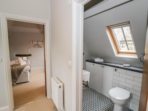 a bathroom with a toilet and a sink and a window at The Old Brewhouse in Chipping Campden