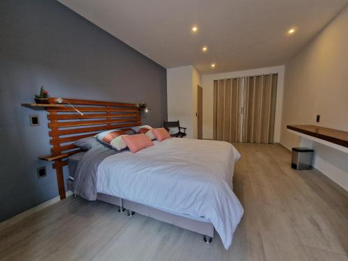a bedroom with a large bed with white sheets and pink pillows at chez Yannick Hospedaje Los Amigos in Salento