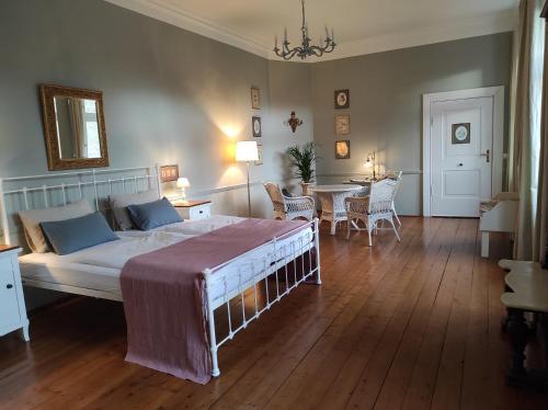 a bedroom with a bed and a table with chairs at Gartenzimmer im Schloss Neuhausen in Neuhausen