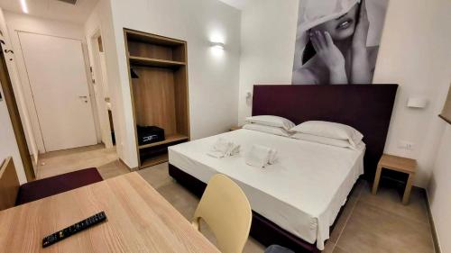 - une chambre dotée d'un lit blanc avec une photo sur le mur dans l'établissement A Nanein con Joy, à Bologne