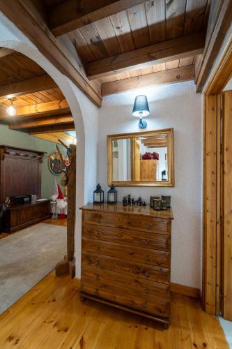 a room with a wooden dresser and a mirror at Dandy Villas Elatodasos - Chalet Artemis - Fir Forest - Jeep & Nature Lovers in Eptalofos