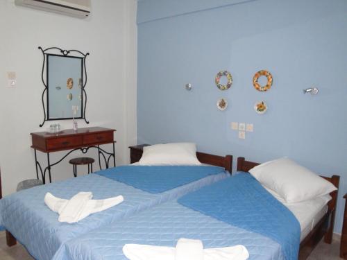 Duas camas num quarto com um espelho e uma secretária. em Filia em Skiathos Town