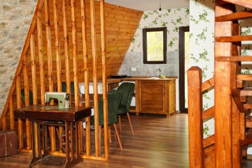 een kamer met een houten trap met groene stoelen bij Artarica in Călugăreni