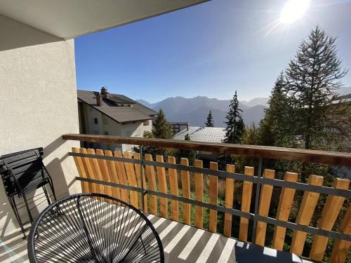 a bench on a balcony with a view of the mountains at Chez Inès - Duplex pour 10 à 12 plein centre in L'Alpe-d'Huez