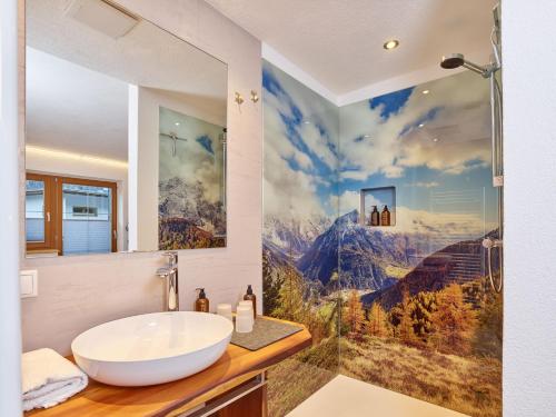 a bathroom with a sink and a large painting on the wall at Haus Laterndl in Längenfeld