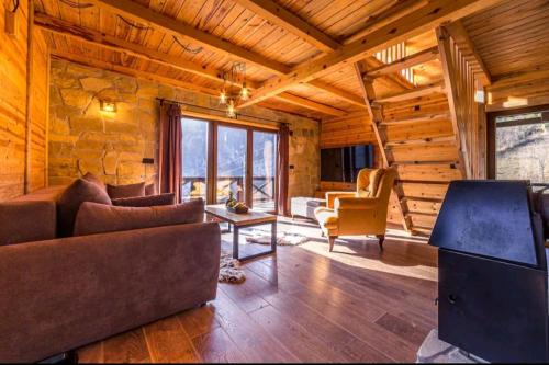 a living room with a couch and chairs in a cabin at Mountain house Potkovica in Lazići