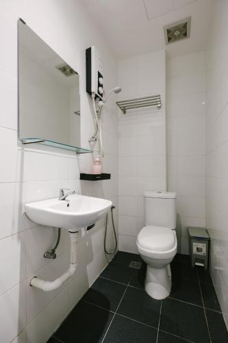 a white bathroom with a sink and a toilet at Kangsar Inn 73 in George Town