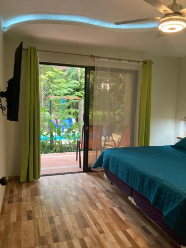 a bedroom with a bed and a sliding glass door at Garza Tigre Apartamentos in Cóbano