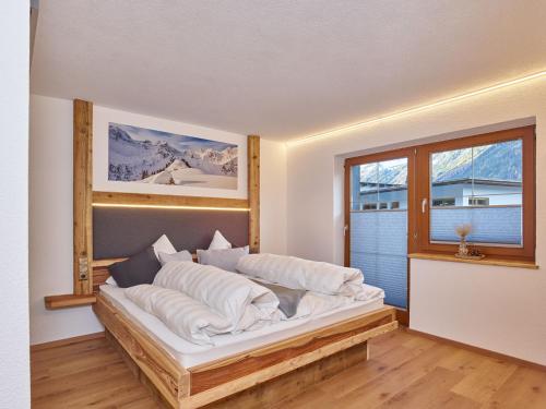 a bedroom with a large white bed with a window at Haus Laterndl in Längenfeld