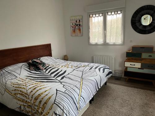 1 dormitorio con 1 cama con edredón blanco y negro en Entre terre et mer en Herbignac