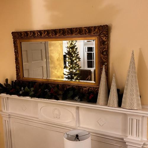 a mirror over a mantle with a christmas tree on it at Carlisle House Bed and Breakfast in Carlisle