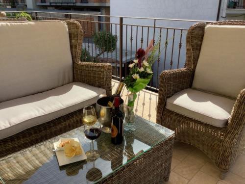 una mesa de cristal con una botella de vino y 2 sillas en SCAPPO IN UMBRIA, Apartments, en Narni Scalo