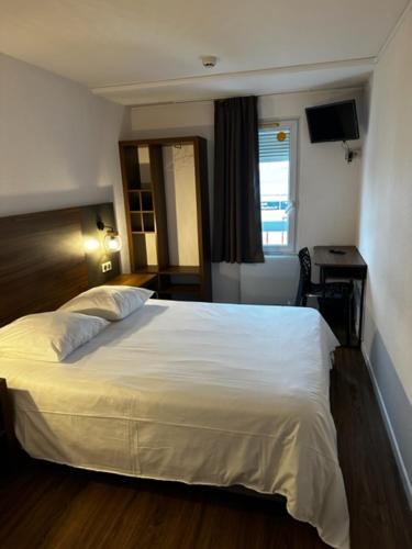 een slaapkamer met een wit bed en een raam bij Hôtel Akena Pierrelaye in Pierrelaye