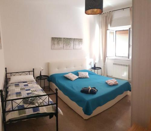Un dormitorio con una cama azul y una ventana en Casa Marna: comodità e praticità con vista Duomo en Massa Marittima