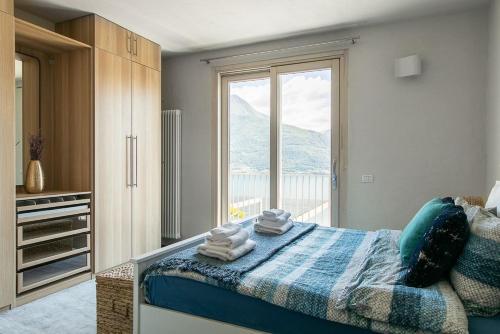 une chambre avec un lit et une grande fenêtre dans l'établissement Tre Terre Panorama - Pianello del Lario by LoveComo, à Pianello Del Lario
