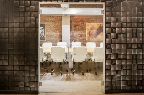 a room with a table and chairs and a brick wall at The Holland Hotel by Simplissimmo in Montreal