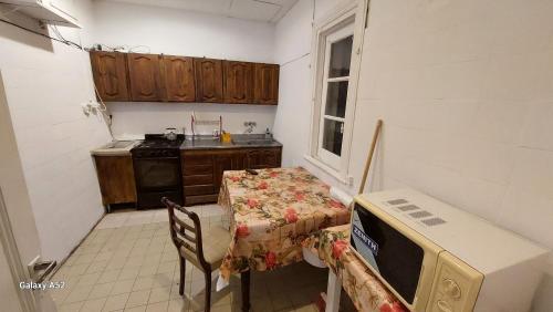 a small kitchen with a table and a microwave at Hostería Almirante Brown in Mar del Plata