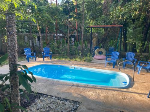 a swimming pool with chairs and a gazebo at Garza Tigre Apartamentos in Cóbano