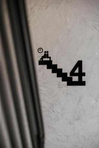 a sign on a wall with stairs on it at Kangsar Inn 73 in George Town