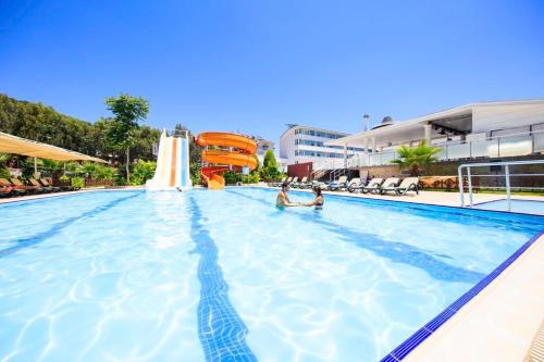 two people in a swimming pool at a resort at Jura Hotels Kemer Resort in Kemer