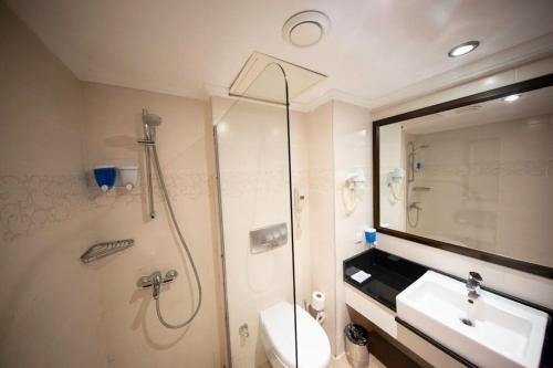 a bathroom with a shower and a toilet and a sink at Jura Hotels Kemer Resort in Kemer