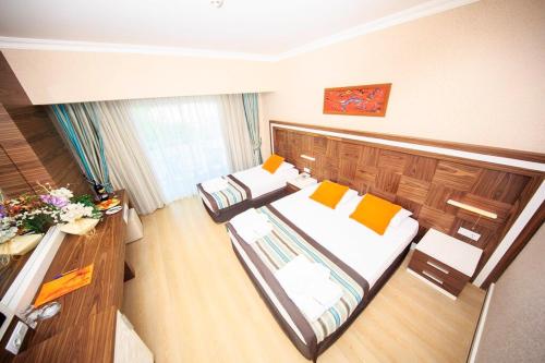 Großes Zimmer mit 2 Betten und einem Schreibtisch. in der Unterkunft Jura Hotels Kemer Resort in Kemer