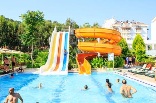 a group of people in a swimming pool with a water slide at Jura Hotels Kemer Resort in Kemer