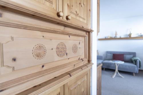 a wooden door in a room with a blue couch at Chasa Grusaida, Vulpera in Vulpera