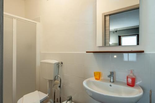 een witte badkamer met een wastafel en een spiegel bij La Bella Toscana Lemon Apartment in Monsummano