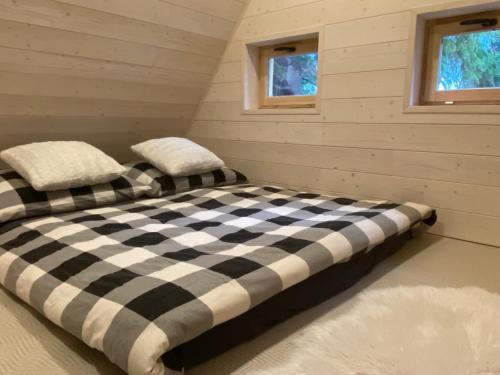 a black and white bed in a room with two windows at Camping Železná Ruda in Železná Ruda