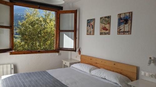a bedroom with a bed and a window at Casa Calpurnia Cerler in Cerler