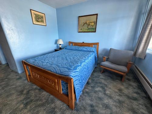 sypialnia z łóżkiem i krzesłem w obiekcie Maverick Motel w mieście Raton