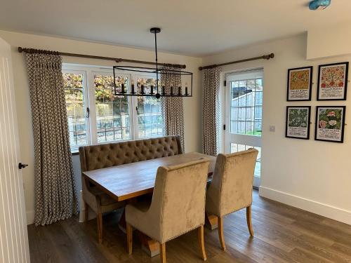a dining room with a wooden table and chairs at Stylish Surrey Hills House 2 ensuite bedrooms in Ockley