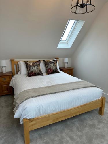 a bedroom with a large bed with a skylight at Stylish Surrey Hills House 2 ensuite bedrooms in Ockley